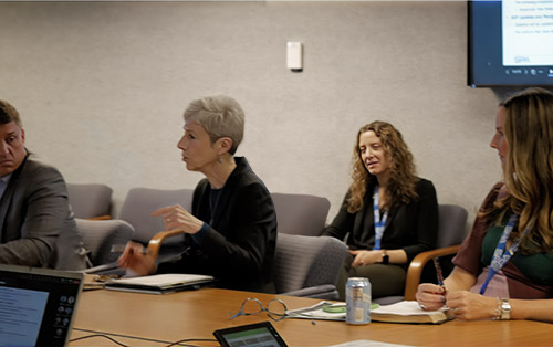 SPA employees discuss a topic during a meeting at HQ
